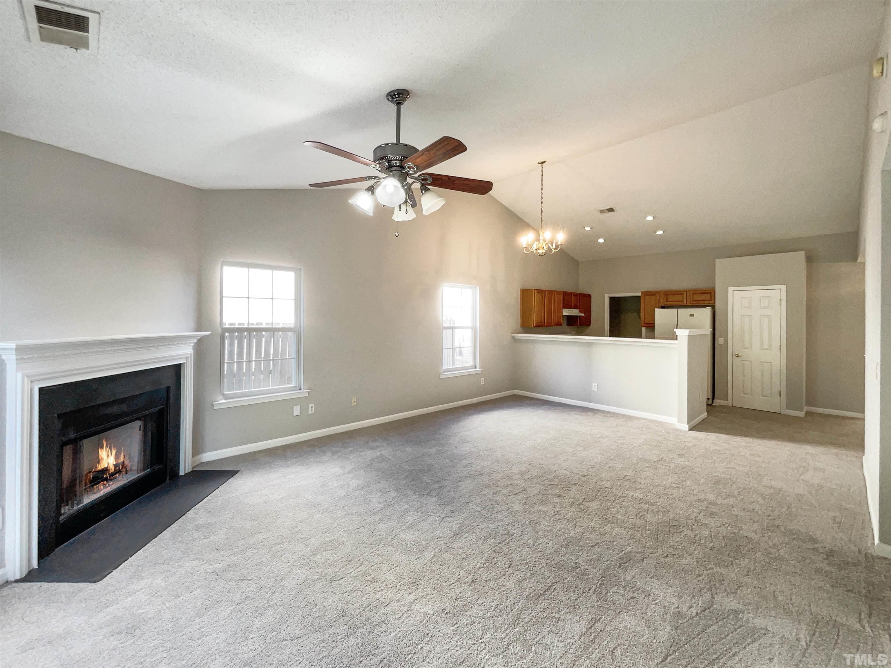 3300 Marcony Way Raleigh, NC 27610 - Photo 14 of 15 a view of a livingroom with a fireplace a ceiling fan and windows