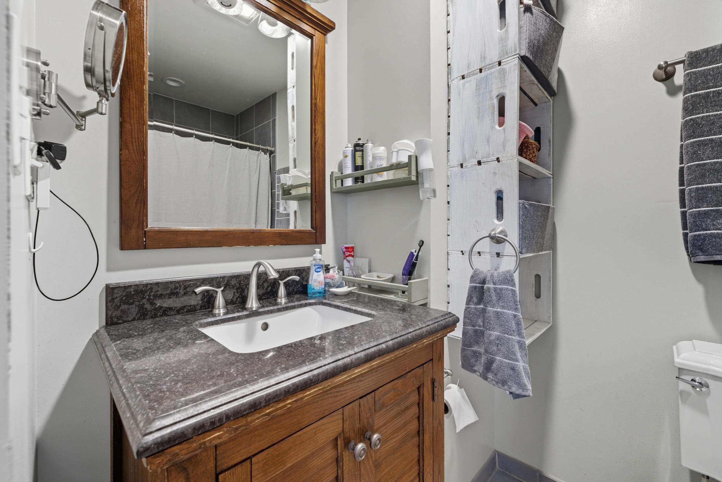8449 Indian Trail Road Harrisonburg, VA 22802 - Photo 30 of 75 a bathroom with a granite countertop sink a toilet and a mirror