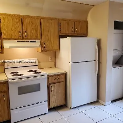 a kitchen with a stove top oven and refrigerator