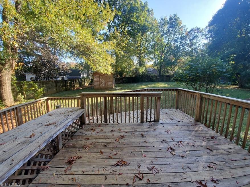 2207 Lane Road Greensboro, NC 27408 - Photo 18 of 19 The deck is in great shape and sports a seating area. The backyard is almost completely fenced. Just a couple of short areas on each end of the house are not fenced. The backyard is nice and grassy.