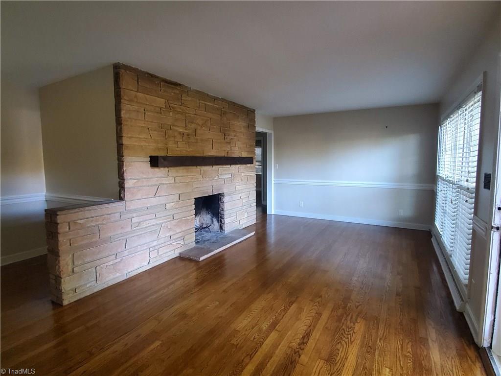2207 Lane Road Greensboro, NC 27408 - Photo 3 of 19 Beautiful hardwoods are in many rooms of this home. The stone fireplace is wood burning. This is the living room.