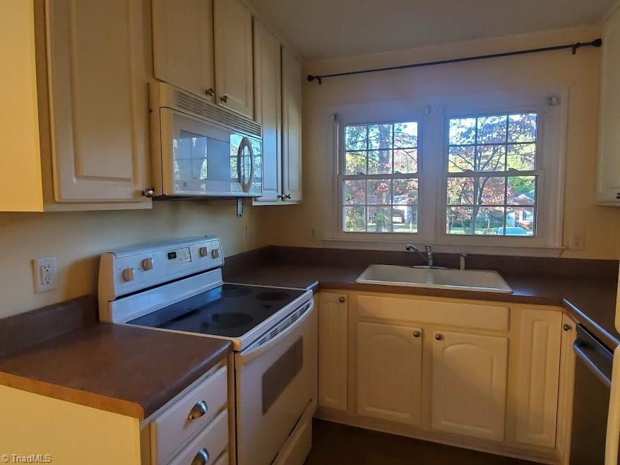 2207 Lane Road Greensboro, NC 27408 - Photo 7 of 19 This compact kitchen has maximized storage with 42" cabinets. The natural light is a good feature. The cabinets are actually white - not the creamy yellow color reflected in the photo.