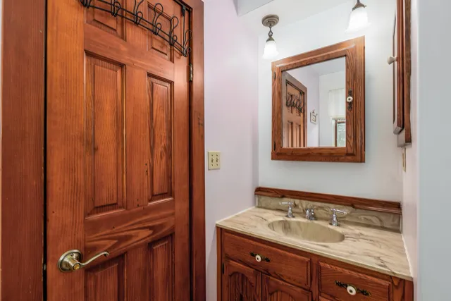 an empty room with wooden floor chandelier fan and windows