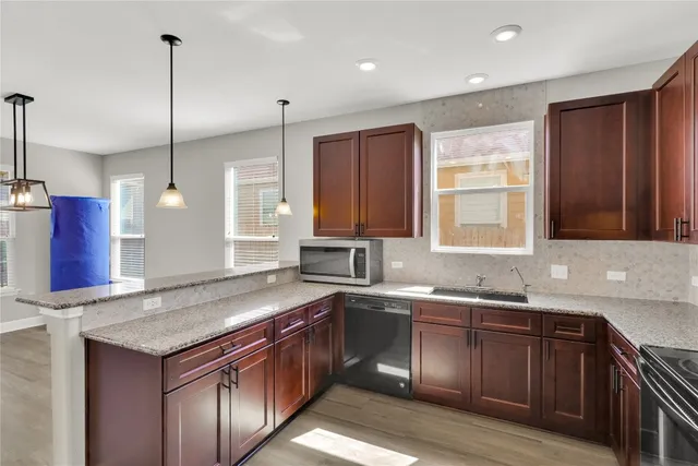 a kitchen with a sink a window and stainless steel appliances