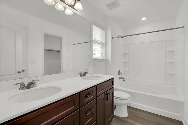a bathroom with a sink double vanity granite tub and a mirror