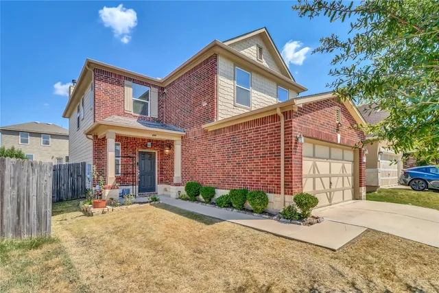 a front view of a house with a yard and potted plants