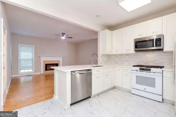 a kitchen with granite countertop a stove top oven microwave and cabinets