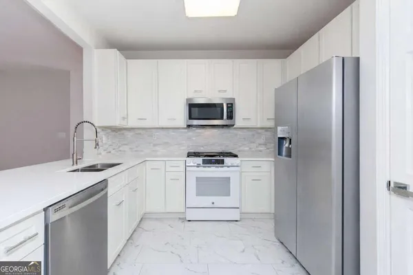 a kitchen with a sink stove and refrigerator