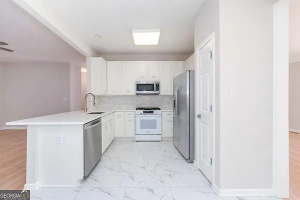 a kitchen with stainless steel appliances granite countertop a refrigerator and a stove