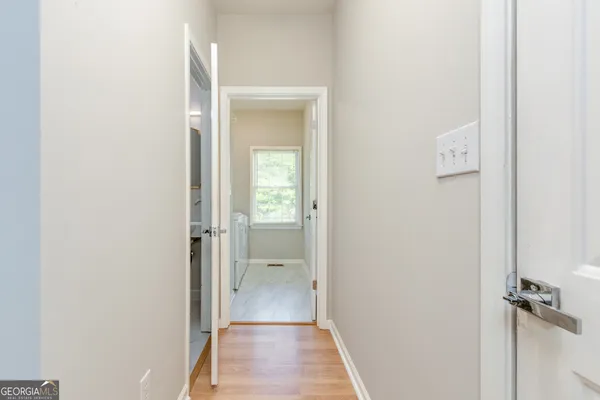 a view of an empty room with wooden floor fireplace and a window