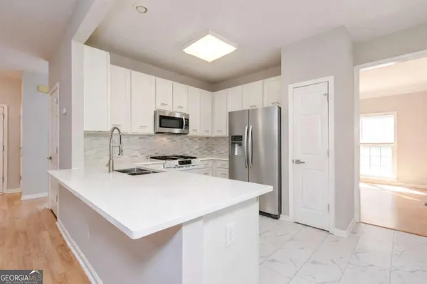 a kitchen with a refrigerator a stove a sink and a microwave