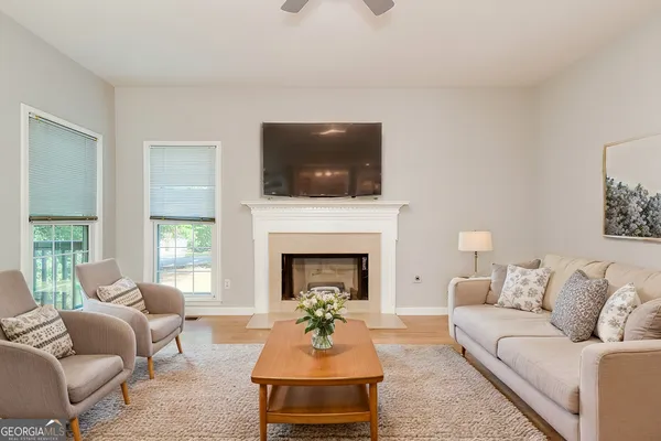 a living room with furniture a flat screen tv and a fireplace