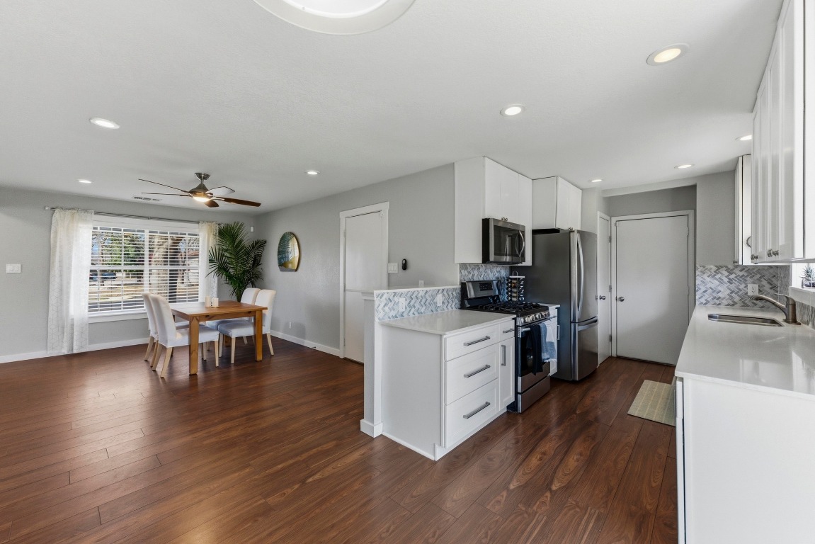 1801 Ohlen Road Austin, TX 78757 - Photo 12 of 29 a kitchen with a sink dishwasher a stove and a refrigerator with wooden floor