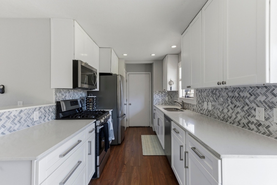 1801 Ohlen Road Austin, TX 78757 - Photo 13 of 29 a kitchen with stainless steel appliances granite countertop a sink stove and refrigerator