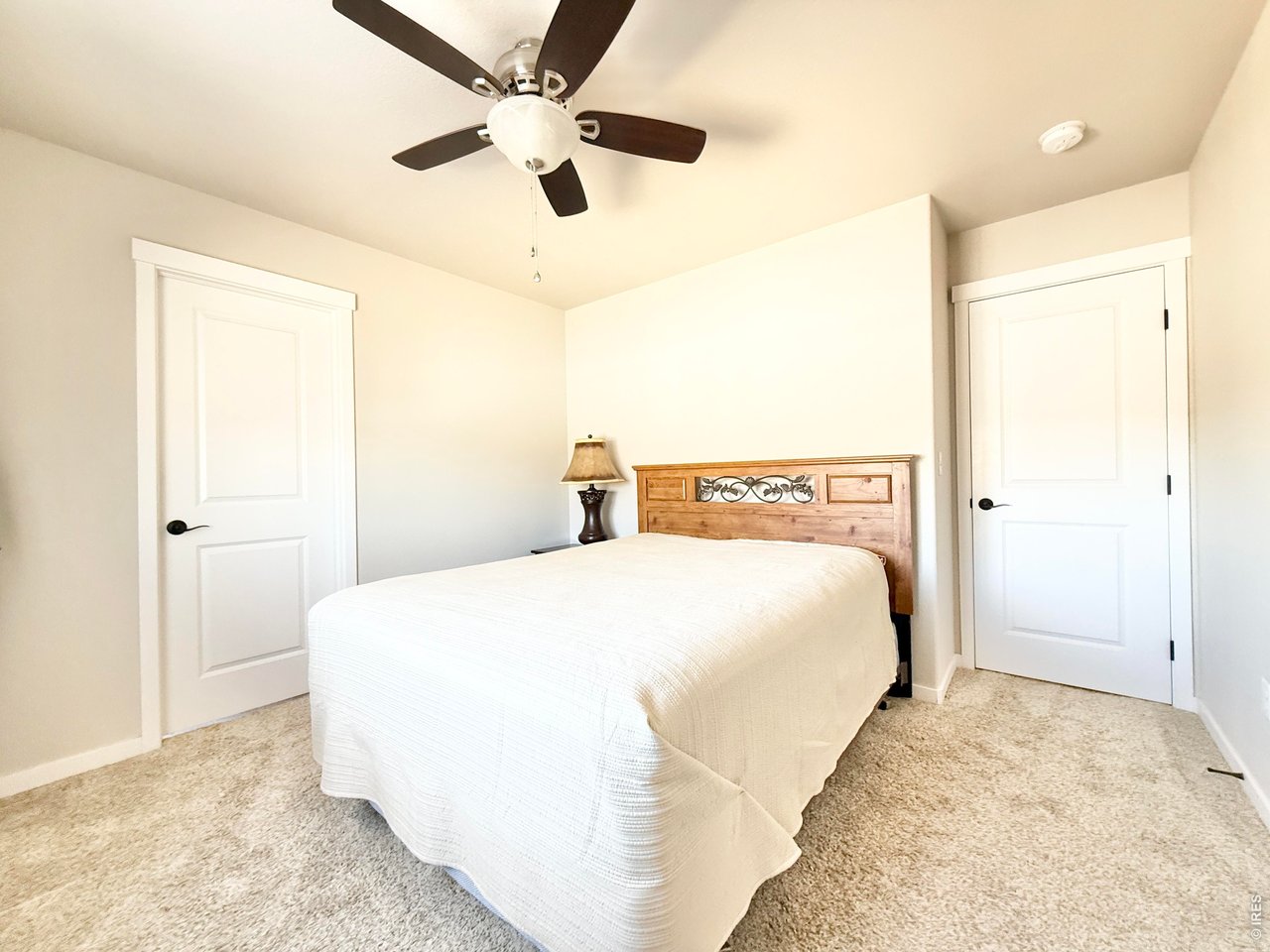 1215 5th Street Pierce, CO 80650 - Photo 12 of 22 a spacious bedroom with a bed and a chandelier