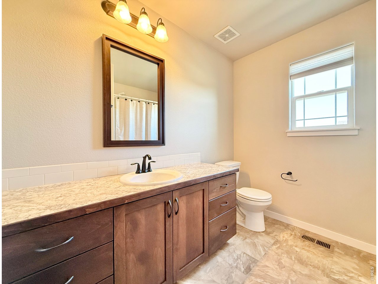 1215 5th Street Pierce, CO 80650 - Photo 13 of 22 a bathroom with a granite countertop sink toilet and mirror