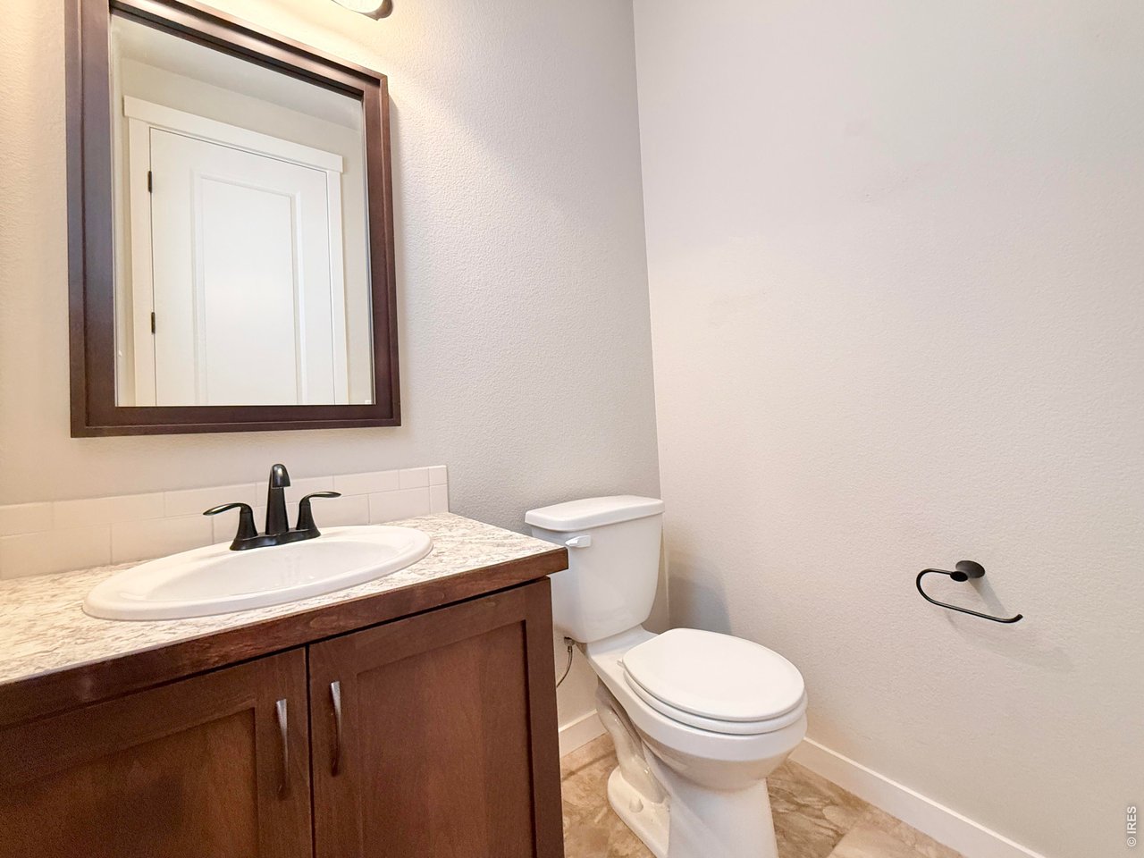 1215 5th Street Pierce, CO 80650 - Photo 8 of 22 a bathroom with a toilet a sink a vanity and mirror