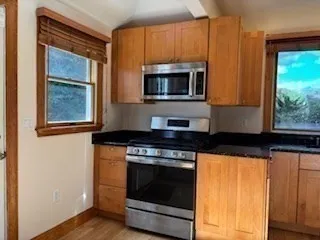 a kitchen with stainless steel appliances granite countertop a stove and a microwave