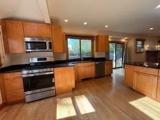 a kitchen with stainless steel appliances kitchen island granite countertop a stove a sink and a microwave