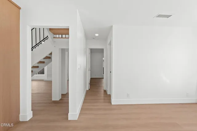a view of a hallway with wooden floor and entryway