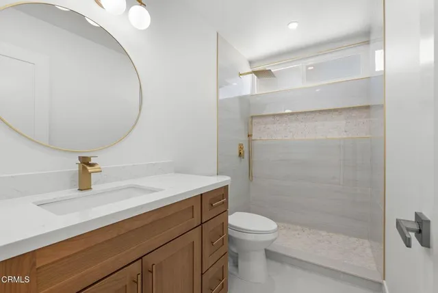 a bathroom with a sink a toilet and shower