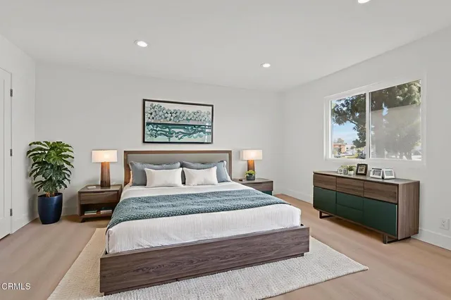 a bedroom with a large bed and a potted plant