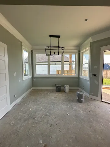 an empty room with windows and furniture