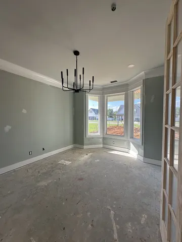 a view of an empty room with a window and fireplace