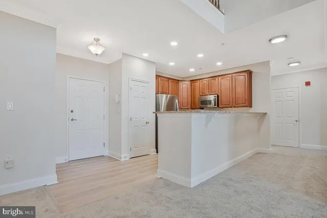 a view of kitchen with granite countertop cabinets and refrigerator