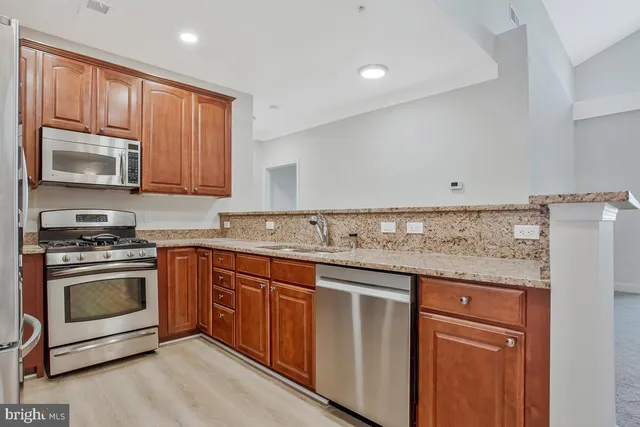 a kitchen with granite countertop cabinets stainless steel appliances and a sink
