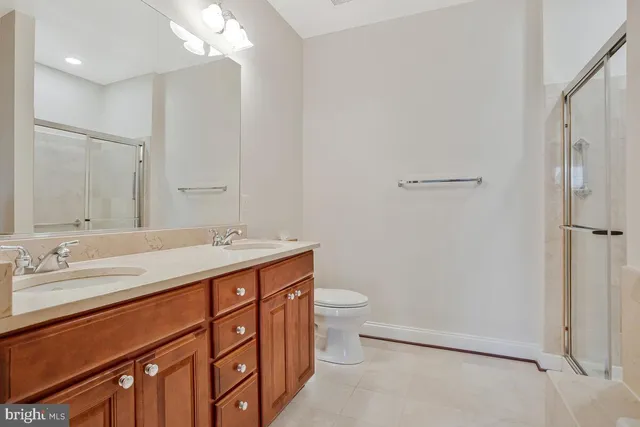 a bathroom with a double vanity sink mirror and toilet
