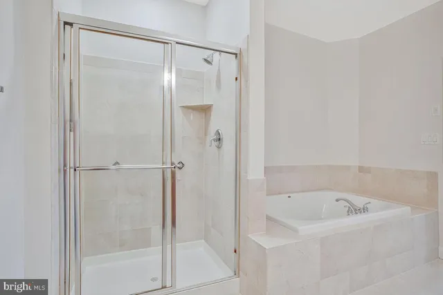 a white bath tub sitting next to a shower