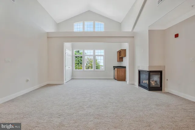 an empty room with a fireplace and a window