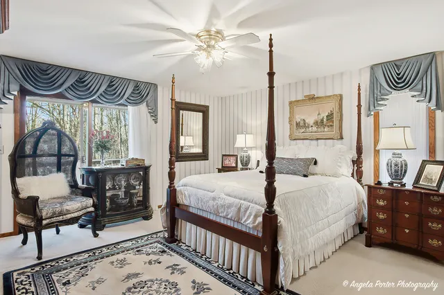 a bedroom with bed and a large mirror on the dresser