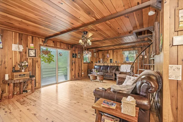 a living room with furniture a wooden floor and next to a window