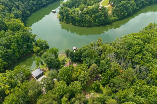 an aerial view of lake residential house with outdoor space and trees around