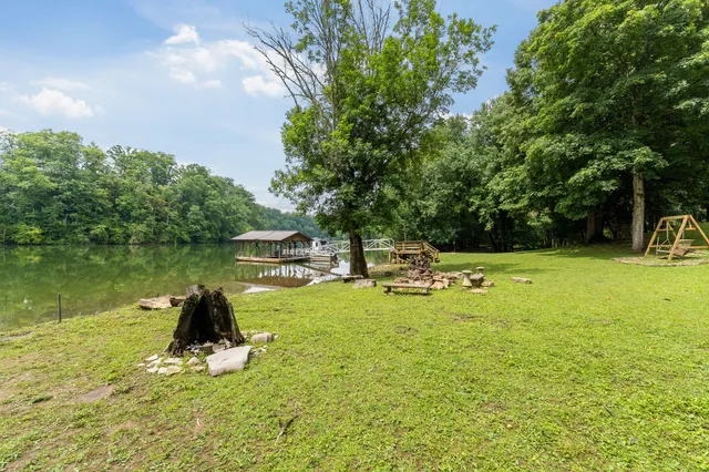 a view of a swimming pool with a table and chairs under an umbrella