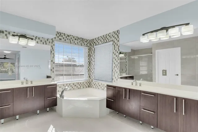 a bathroom with a tub a sink and a shower