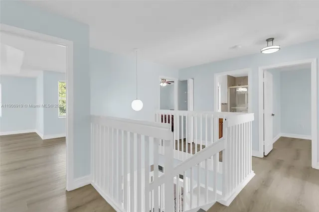 a view of a hallway with wooden floor and entryway