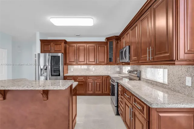 a kitchen with stainless steel appliances granite countertop a sink dishwasher stove and refrigerator