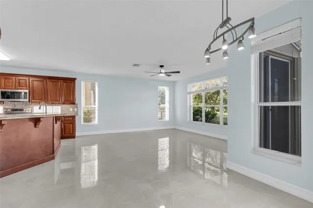 a open kitchen with stainless steel appliances granite countertop a refrigerator and a stove top oven