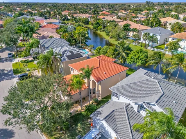 an aerial view of a house with a yard and lake view