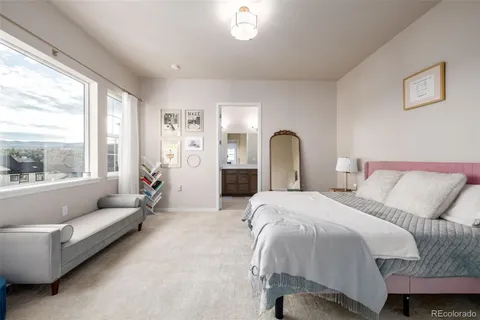 a bedroom with a bed couch and a window