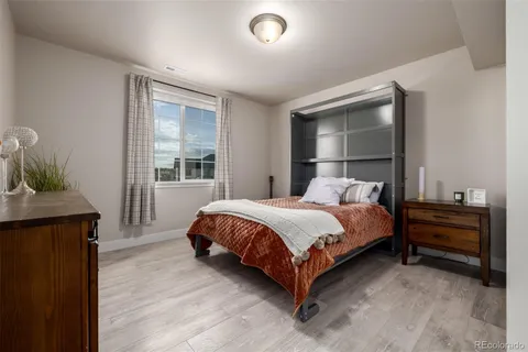 a bed sitting in a bedroom next to a window and dresser