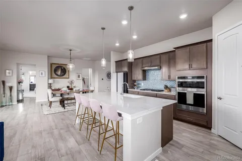 a large kitchen with kitchen island a large island a sink a stove and cabinets