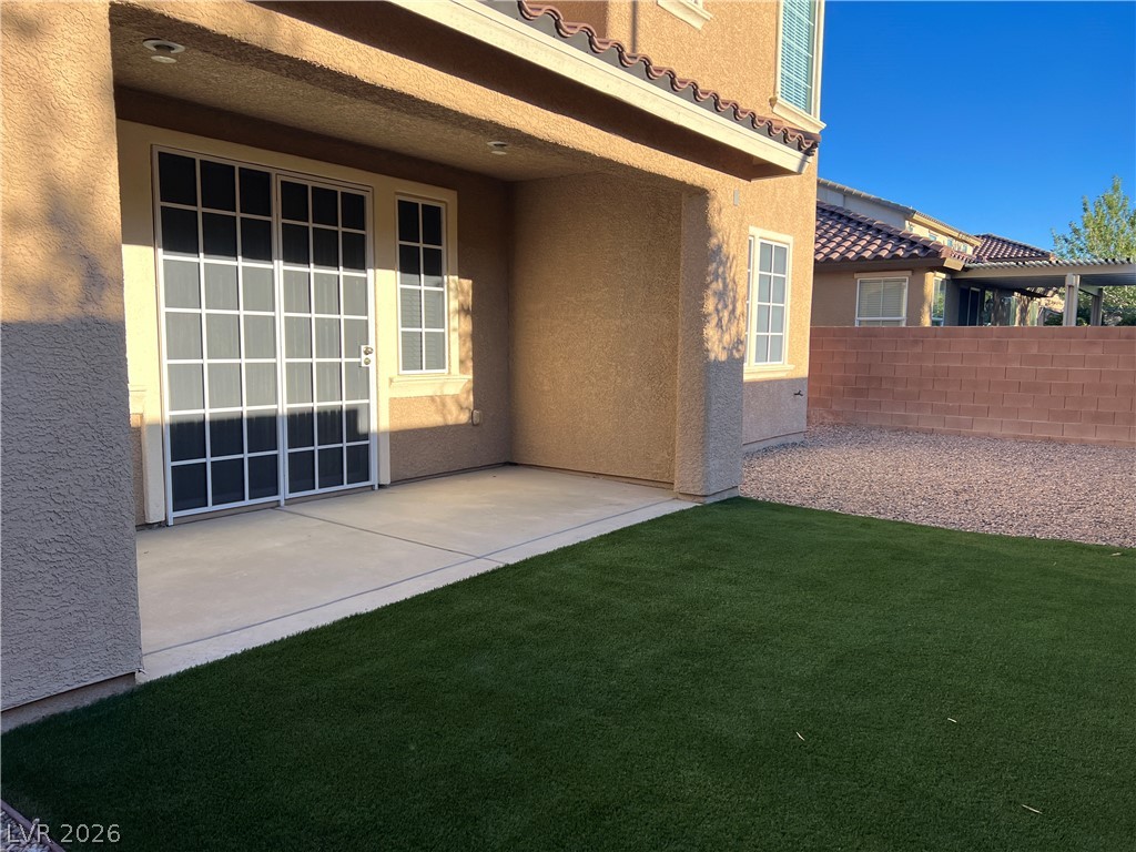 5981 Honeysuckle Ridge Street Las Vegas, NV 89148 - Photo 29 of 29 A private backyard oasis features a paved patio, low-maintenance turf, and a solid privacy wall.