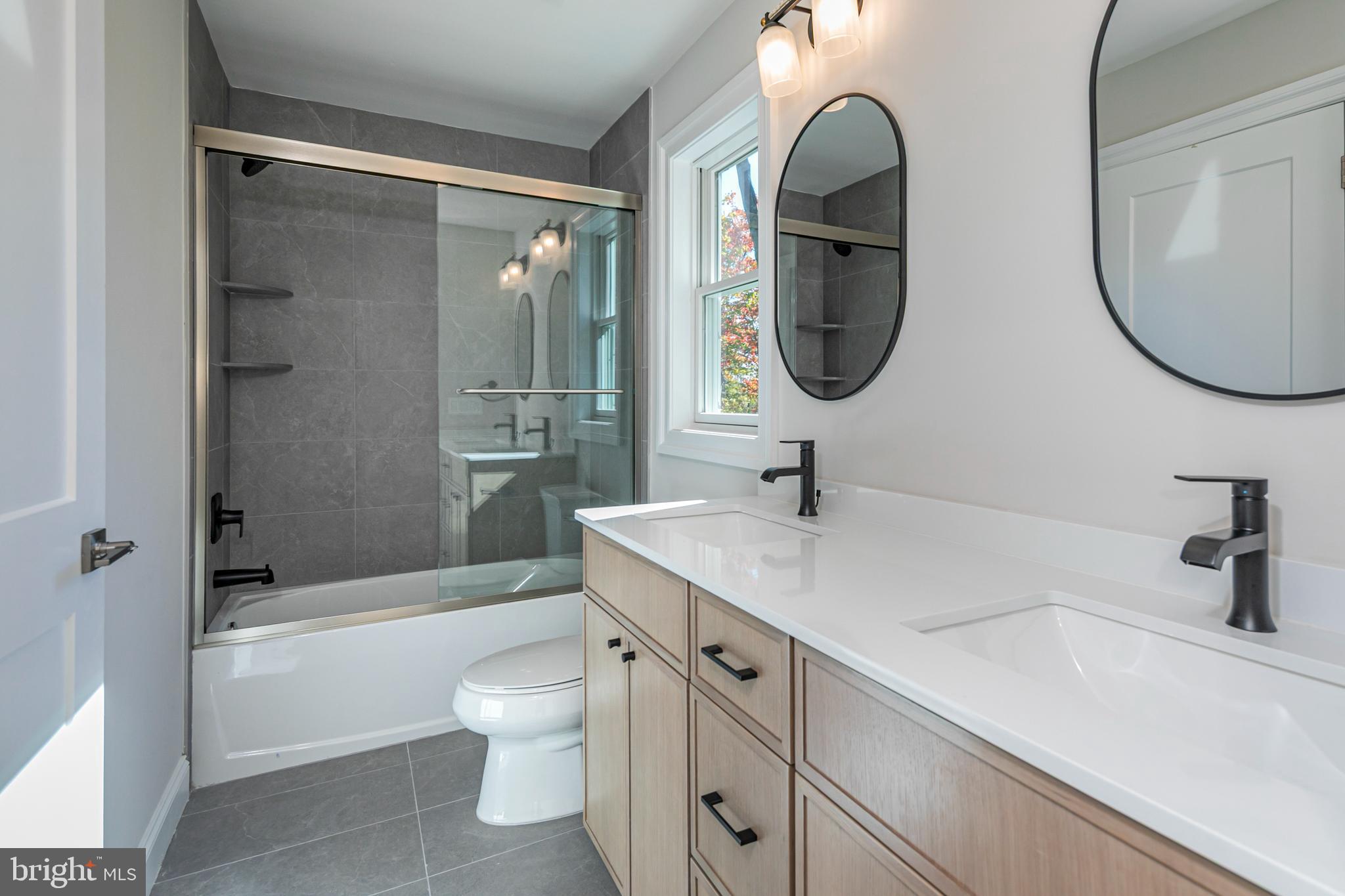 576 Ewing Street Princeton, NJ 08540 - Photo 44 of 61 a bathroom with a granite countertop toilet a sink and a mirror