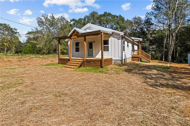 a view of a house with a yard and sitting area