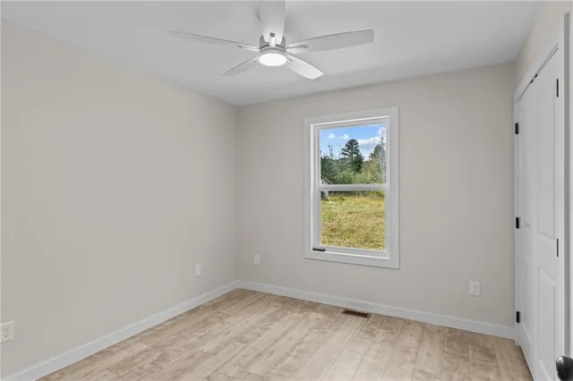 an empty room with window and ceiling fan