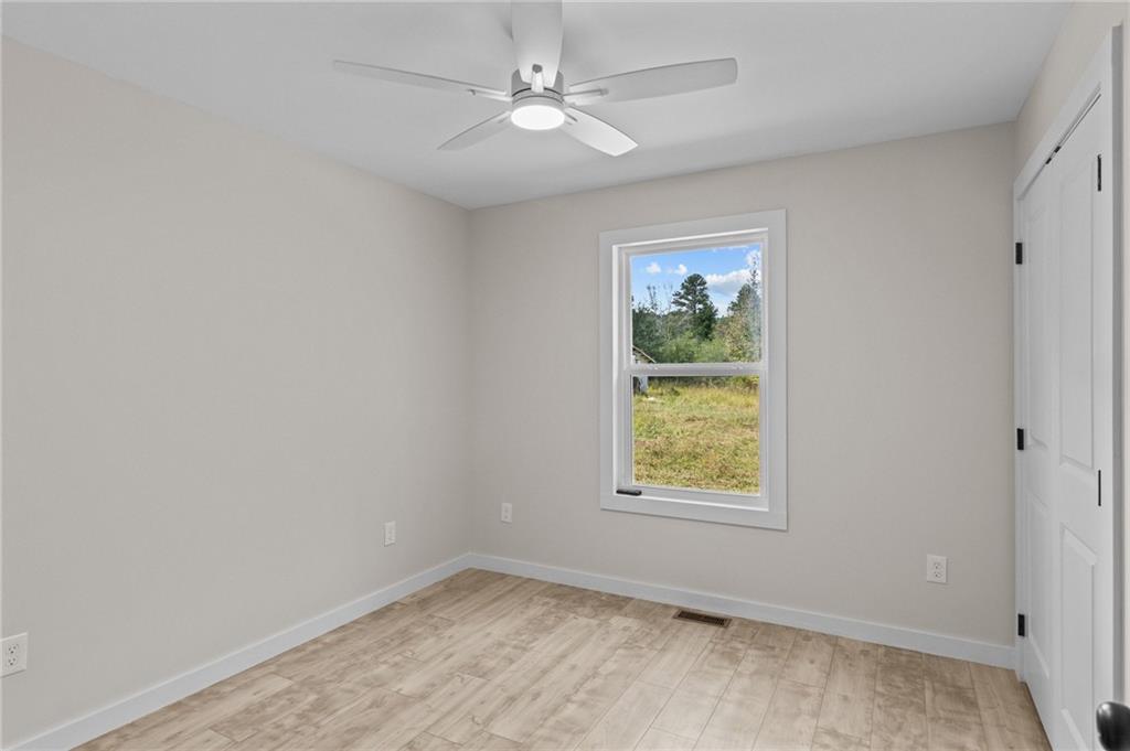 94 Orchard Road Summerville, GA 30747 - Photo 5 of 11 an empty room with window and ceiling fan